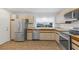 Galley kitchen with stainless steel appliances and light beige cabinets at 6908 Emerald Springs Ln, Las Vegas, NV 89113