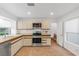 Galley kitchen with stainless steel appliances and light beige cabinets at 6908 Emerald Springs Ln, Las Vegas, NV 89113