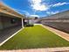 Landscaped backyard with artificial turf and covered patio at 730 Brick Dr, Henderson, NV 89002