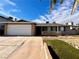 House exterior with a white garage door and artificial turf at 730 Brick Dr, Henderson, NV 89002