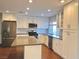 Modern kitchen with white shaker cabinets, stainless steel appliances and an island at 730 Brick Dr, Henderson, NV 89002