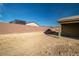 Backyard with large empty lot, block wall, and covered patio at 74 Wildcat Ave, Pahrump, NV 89060