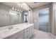 Double vanity bathroom with modern light fixture and large mirror at 8130 Skye Sweep St, Las Vegas, NV 89166