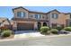 Two-story house with brown garage doors and green shutters at 9221 Black Lake Pl, Las Vegas, NV 89178