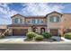 Two-story house with brown garage doors and green shutters at 9221 Black Lake Pl, Las Vegas, NV 89178