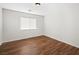 Bright bedroom featuring dark brown laminate floors and a window at 9307 Bondeno St, Las Vegas, NV 89123