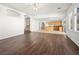 Open living room with kitchen and stairs, featuring dark laminate floors at 9307 Bondeno St, Las Vegas, NV 89123