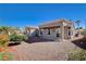 Beautiful backyard featuring well-kept gravel, landscaping, and covered patio areas, perfect for entertaining at 10300 Bent Brook Pl, Las Vegas, NV 89134