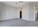 Large bedroom with soft carpet and neutral walls, featuring a walk-in closet and attached bathroom at 10300 Bent Brook Pl, Las Vegas, NV 89134