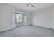 Spacious bedroom with plush carpet, ceiling fan, and large windows offering plenty of natural light at 10300 Bent Brook Pl, Las Vegas, NV 89134