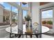 Bright dining area with glass table and chairs, illuminated by large windows providing ample natural light at 10300 Bent Brook Pl, Las Vegas, NV 89134