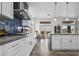 Elegant kitchen featuring white cabinetry, modern appliances, and stylish backsplash, flowing to breakfast nook area at 10300 Bent Brook Pl, Las Vegas, NV 89134