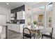 Modern kitchen featuring white cabinets, dark backsplash, stainless steel appliances, and breakfast nook area at 10300 Bent Brook Pl, Las Vegas, NV 89134