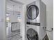 Convenient laundry room with a modern stacked washer and dryer set next to the kitchen at 10300 Bent Brook Pl, Las Vegas, NV 89134