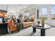 Bright living room featuring a leather sofa, rug and large windows at 10300 Bent Brook Pl, Las Vegas, NV 89134