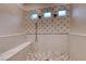 Spa-like shower with patterned tile and pebble floor at 116 Stone Mesa Ct, Henderson, NV 89011