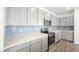 Well-appointed kitchen with gray cabinets, stylish backsplash, and quartz countertops at 4540 S Pienza Ct, Pahrump, NV 89061