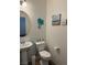 Small bathroom with pedestal sink, toilet, and beach decor at 616 Taliput Palm Pl, Henderson, NV 89011