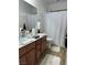 Clean bathroom with double sinks, shower, and a patterned curtain at 616 Taliput Palm Pl, Henderson, NV 89011