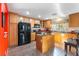 Kitchen with wooden cabinets, black appliances, and island at 87 Japonica Ave, Las Vegas, NV 89183