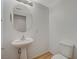 Powder room with pedestal sink, round mirror, and modern toilet at 9204 Weeping Hollow Ave, Las Vegas, NV 89178