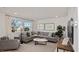 Spacious living room with gray sectional sofa and large windows at 925 Watford Pl, Henderson, NV 89011