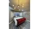 Large main bedroom with a king-size bed and stylish chandelier at 9356 Sparkling Waters Ave, Las Vegas, NV 89129