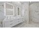 Modern bathroom with double vanity, marble walls, and walk-in shower at 9605 Verlaine Ct, Las Vegas, NV 89145
