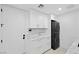 Modern laundry room with white cabinets, marble countertops, and stacked LG washer/dryer at 9605 Verlaine Ct, Las Vegas, NV 89145