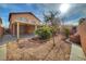 Spacious backyard with gravel landscaping, covered patio, and mature plants at 10279 Montes Vascos Dr, Las Vegas, NV 89178