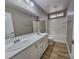 Clean bathroom with double vanity and a bathtub shower combo at 10279 Montes Vascos Dr, Las Vegas, NV 89178