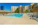 Community pool with lounge chairs, surrounded by a fence and building at 205 E Harmon Ave # 609, Las Vegas, NV 89169
