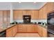 L-shaped kitchen with granite counters and wood cabinets at 2470 Lothian St, Henderson, NV 89044