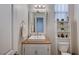 Simple bathroom with white vanity, toilet and decorative mirror at 5694 Colbert St, North Las Vegas, NV 89081