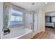 Bathroom with soaking tub, walk-in shower, and view into bedroom at 5694 Colbert St, North Las Vegas, NV 89081