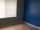 Bedroom with gray and blue walls, and light brown laminate flooring at 6681 Bubbling Brook Dr # A, Las Vegas, NV 89107