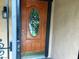 Wood front door with oval glass window and brass hardware at 6681 Bubbling Brook Dr # A, Las Vegas, NV 89107