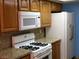 Kitchen with wood cabinets, granite counters, and appliances at 6681 Bubbling Brook Dr # A, Las Vegas, NV 89107