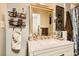 Decorated bathroom with a granite-look vanity top, vintage gold mirror and fixtures, and decorative wall storage at 919 Havre Ave, Henderson, NV 89015