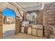 Covered outdoor kitchen with stainless steel appliances set against a stone-textured backdrop at 919 Havre Ave, Henderson, NV 89015