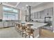 Modern kitchen featuring stainless steel appliances, gray cabinets, a large island with seating, and a bright window at 10301 Fairview Ridge Ct, Las Vegas, NV 89166