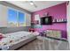 This charming bedroom features a large window, a TV, carpet flooring, and colorful décor at 10729 Beecher Park Ave, Las Vegas, NV 89166