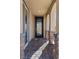 Inviting front porch featuring stylish stone pillars, a decorative chair and a paved entrance at 10729 Beecher Park Ave, Las Vegas, NV 89166