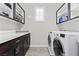 Laundry room with modern washer and dryer, storage cabinets, countertop space, and a window for natural light at 10729 Beecher Park Ave, Las Vegas, NV 89166