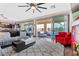 Spacious living room with a large sliding door, modern ceiling fan, stylish rug, and comfortable seating area at 10729 Beecher Park Ave, Las Vegas, NV 89166