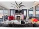 Cozy living room with a stone fireplace, large ceiling fan, and comfortable seating at 10729 Beecher Park Ave, Las Vegas, NV 89166