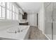 This bathroom features a soaking tub, a separate glass shower, tiled floors and a window with plantation shutters at 10729 Beecher Park Ave, Las Vegas, NV 89166