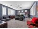This spacious main bedroom features a sitting area with a couch and fireplace, windows with plantation shutters and carpeted floors at 10729 Beecher Park Ave, Las Vegas, NV 89166