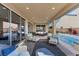 Spacious covered patio area with comfortable seating, a view of the pool, and multiple entry points to the house at 10729 Beecher Park Ave, Las Vegas, NV 89166