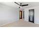 Minimalist bedroom with neutral carpet, modern ceiling fan, and a glass paneled door at 1630 Westwood Dr, Las Vegas, NV 89102